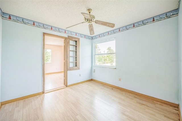 1601 Randolph St, Deltona, FL 32725 - empty room featuring plenty of natural light, light wood-type flooring, a textured ceiling, a ceiling fan, and baseboards