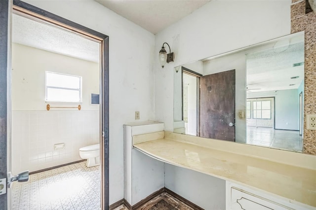 1601 Randolph St, Deltona, FL 32725 - bathroom with toilet, a wainscoted wall, tile walls, and ceiling fan