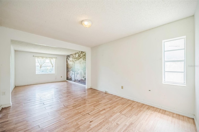 1601 Randolph St, Deltona, FL 32725 - empty room with light wood finished floors, a textured ceiling, and baseboards