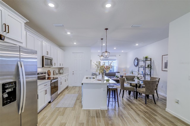 625 Dogfish Ln, Debary, FL 32713 - kitchen featuring appliances with stainless steel finishes, a sink, light wood-type flooring, light countertops, and white cabinetry