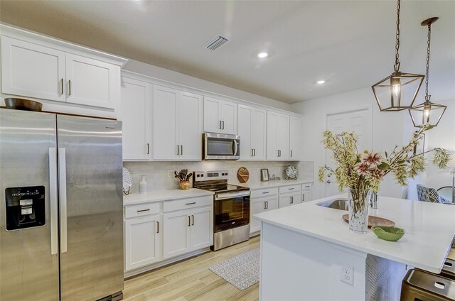 625 Dogfish Ln, Debary, FL 32713 - kitchen featuring appliances with stainless steel finishes, light countertops, white cabinetry, backsplash, and light wood-style flooring