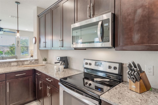 15241 Sunrise Grove Ct, Winter Garden, FL 34787 - kitchen with stainless steel appliances, dark brown cabinets, light stone countertops, a ceiling fan, and hanging light fixtures