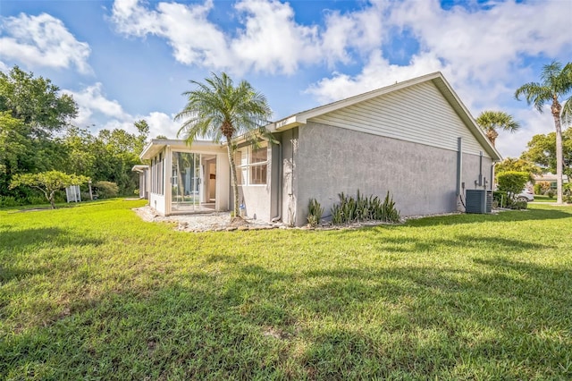 2015 Gardenia Landings Ln, Sun City Center, FL 33573 - rear view of house with a sunroom, stucco siding, a lawn, and cooling unit
