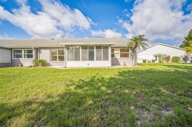 2015 Gardenia Landings Ln, Sun City Center, FL 33573 - back of property with a sunroom, a lawn, and stucco siding