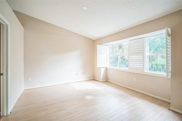 2015 Gardenia Landings Ln, Sun City Center, FL 33573 - spare room featuring baseboards, lofted ceiling, a textured ceiling, and wood finished floors