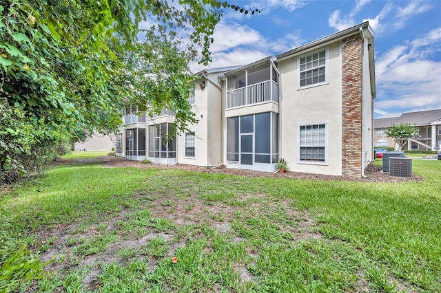 141 Reserve Cir Unit 113, Oviedo, FL 32765 - rear view of house featuring a sunroom, a lawn, stucco siding, and cooling unit