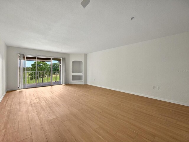 13917 Fairway Island Dr Unit 931, Orlando, FL 32837 - unfurnished room with light wood-style flooring, baseboards, and arched walkways