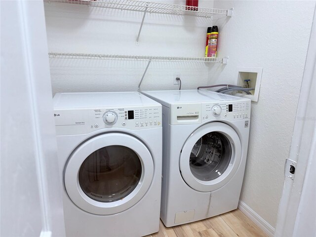 13917 Fairway Island Dr Unit 931, Orlando, FL 32837 - laundry area featuring washing machine and clothes dryer, light wood finished floors, and baseboards