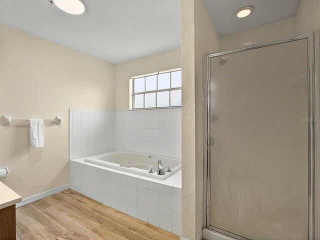 13917 Fairway Island Dr Unit 931, Orlando, FL 32837 - bathroom with vanity, a bath, wood finished floors, a stall shower, and baseboards