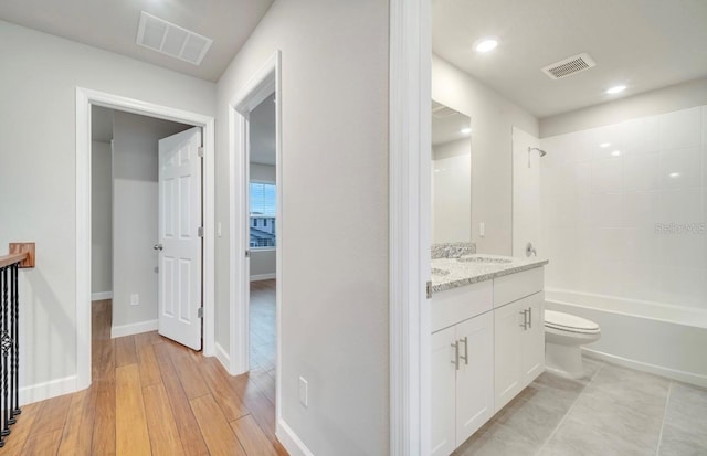 491 Whistling Duck Trl, Saint Cloud, FL 34771 - bathroom with vanity, toilet, tub / shower combination, wood finished floors, and baseboards