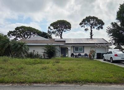 1343 SE Vestridge Ln, Port St Lucie, FL 34952 - ranch-style home with solar panels and a front yard