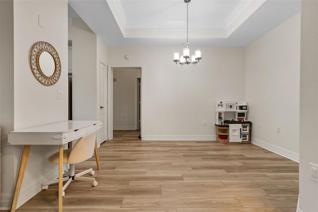 500 Mirasol Cir Unit 203, Celebration, FL 34747 - dining room with a raised ceiling, light wood-type flooring, ornamental molding, a chandelier, and baseboards