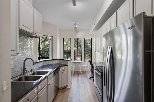500 Mirasol Cir Unit 203, Celebration, FL 34747 - kitchen with appliances with stainless steel finishes, a sink, backsplash, light wood-style floors, and white cabinetry