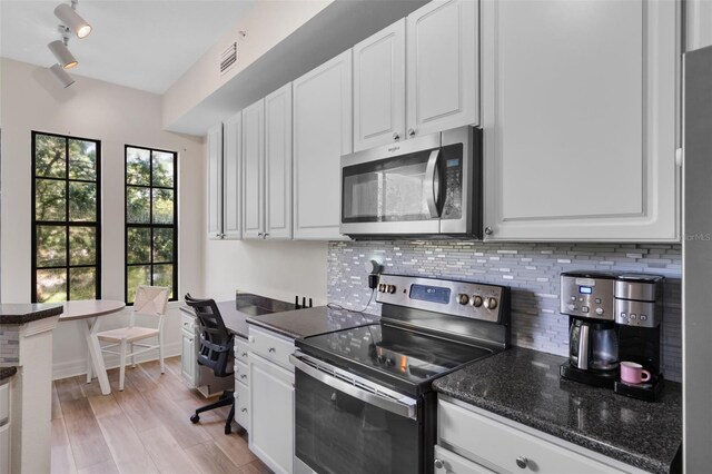 500 Mirasol Cir Unit 203, Celebration, FL 34747 - kitchen featuring stainless steel appliances, decorative backsplash, and white cabinets