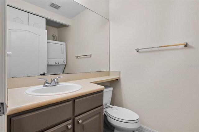500 Mirasol Cir Unit 203, Celebration, FL 34747 - bathroom featuring stacked washing machine and dryer, vanity, toilet, and baseboards