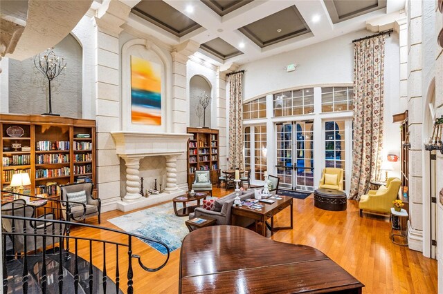 500 Mirasol Cir Unit 203, Celebration, FL 34747 - living area featuring wood finished floors, coffered ceiling, a towering ceiling, beam ceiling, and a fireplace with raised hearth