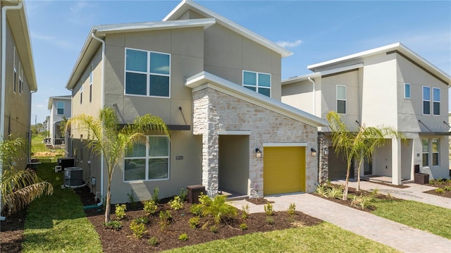 8964 Takeaway Way, Davenport, FL 33896 - modern home featuring stone siding, stucco siding, a garage, and driveway
