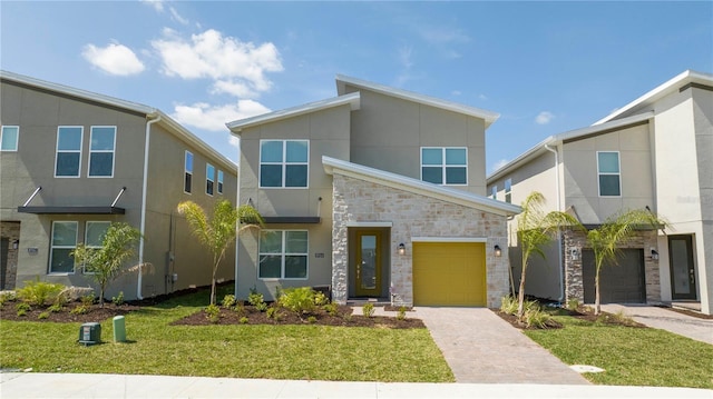 8964 Takeaway Way, Davenport, FL 33896 - contemporary house featuring stone siding, stucco siding, an attached garage, driveway, and a front lawn