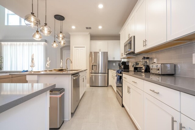 8964 Takeaway Way, Davenport, FL 33896 - kitchen featuring stainless steel appliances, decorative backsplash, light tile patterned flooring, white cabinets, and recessed lighting