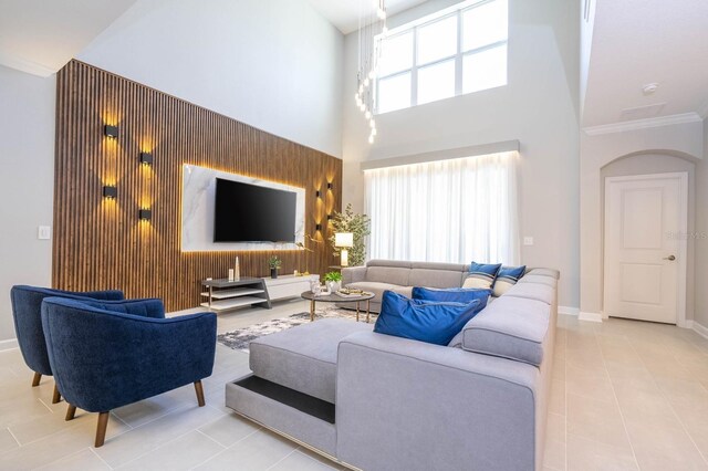 8964 Takeaway Way, Davenport, FL 33896 - living room with tile patterned flooring, a high ceiling, baseboards, arched walkways, and ornamental molding