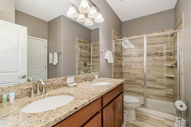 1403 Rolling Fairway Dr, Davenport, FL 33896 - bathroom with a chandelier, toilet, a shower stall, double vanity, and wood finished floors