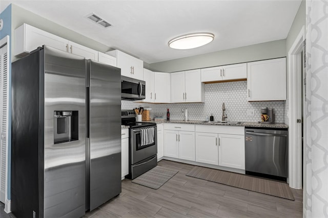 752 Howland Ln Unit 114, Altamonte Springs, FL 32701 - kitchen featuring appliances with stainless steel finishes, a sink, white cabinets, light stone countertops, and decorative backsplash
