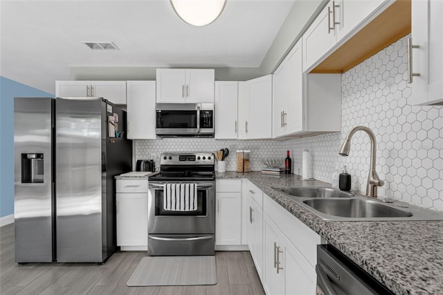752 Howland Ln Unit 114, Altamonte Springs, FL 32701 - kitchen featuring appliances with stainless steel finishes, a sink, white cabinets, and decorative backsplash