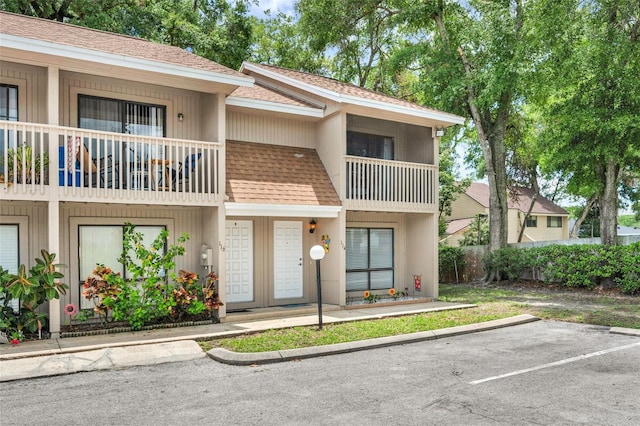 752 Howland Ln Unit 114, Altamonte Springs, FL 32701 - view of front of house featuring a balcony, a shingled roof, and uncovered parking