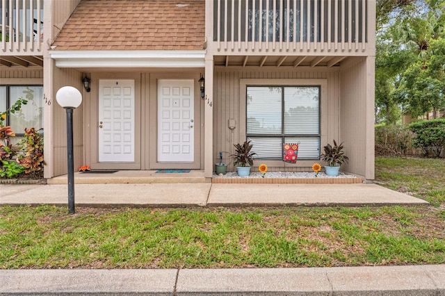 752 Howland Ln Unit 114, Altamonte Springs, FL 32701 - view of exterior entry featuring a shingled roof and a balcony