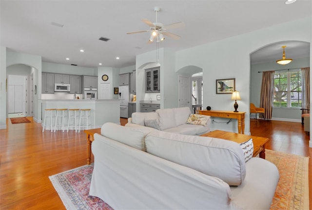 3372 Bellington Dr, Orlando, FL 32835 - living room with arched walkways, a ceiling fan, light wood-style flooring, baseboards, and recessed lighting