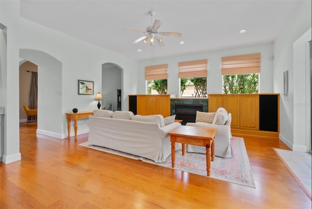 3372 Bellington Dr, Orlando, FL 32835 - living area with healthy amount of natural light, a glass covered fireplace, a ceiling fan, light wood-type flooring, and recessed lighting