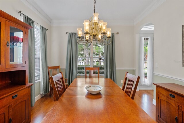 3372 Bellington Dr, Orlando, FL 32835 - dining area with a chandelier, light wood finished floors, healthy amount of natural light, and crown molding