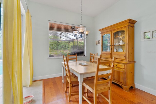 3372 Bellington Dr, Orlando, FL 32835 - dining room featuring a chandelier, light wood-style floors, and baseboards