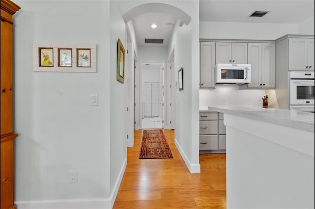 3372 Bellington Dr, Orlando, FL 32835 - corridor with light wood-type flooring, arched walkways, recessed lighting, and baseboards