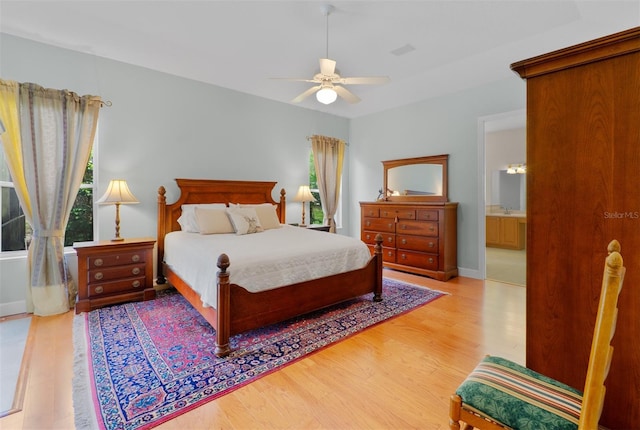 3372 Bellington Dr, Orlando, FL 32835 - bedroom featuring wood finished floors, a ceiling fan, baseboards, and connected bathroom