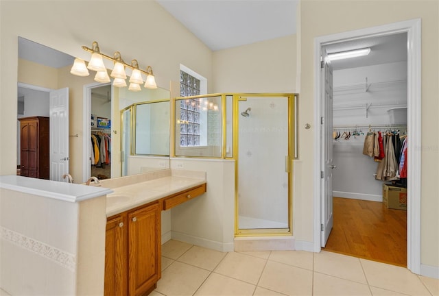 3372 Bellington Dr, Orlando, FL 32835 - bathroom with a walk in closet, a shower stall, vanity, and tile patterned flooring