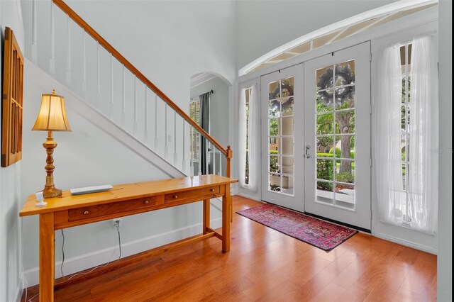 3372 Bellington Dr, Orlando, FL 32835 - foyer featuring wood finished floors, stairs, arched walkways, and a high ceiling