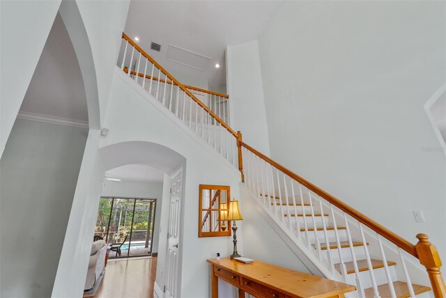 3372 Bellington Dr, Orlando, FL 32835 - stairway with a towering ceiling, arched walkways, baseboards, and wood finished floors