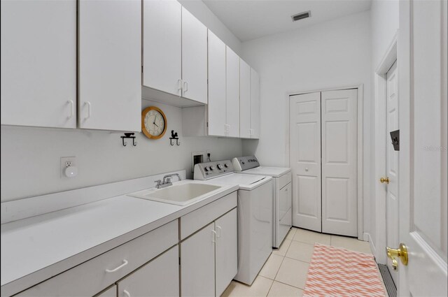 3372 Bellington Dr, Orlando, FL 32835 - washroom featuring cabinet space, washer and dryer, and light tile patterned floors