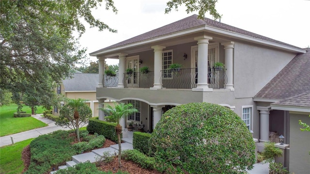 3372 Bellington Dr, Orlando, FL 32835 - neoclassical home with stucco siding, a shingled roof, and a balcony