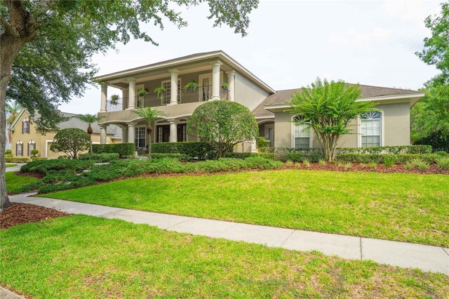 3372 Bellington Dr, Orlando, FL 32835 - view of front of property featuring a balcony, stucco siding, and a front yard
