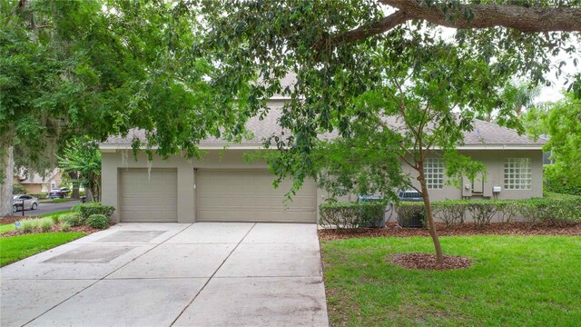 3372 Bellington Dr, Orlando, FL 32835 - view of front of house featuring stucco siding, driveway, a shingled roof, a front yard, and a garage