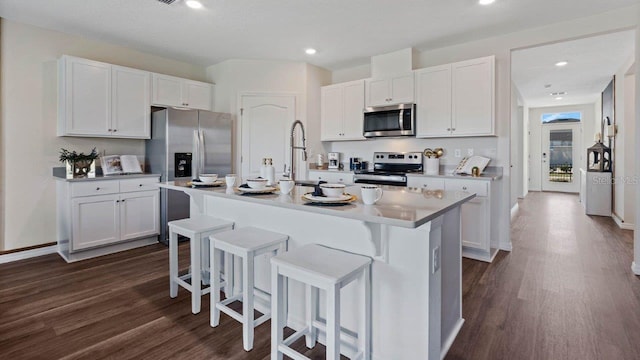 3141 Partington Blvd, Davenport, FL 33837 - kitchen featuring stainless steel appliances, dark wood finished floors, a breakfast bar area, white cabinetry, and recessed lighting