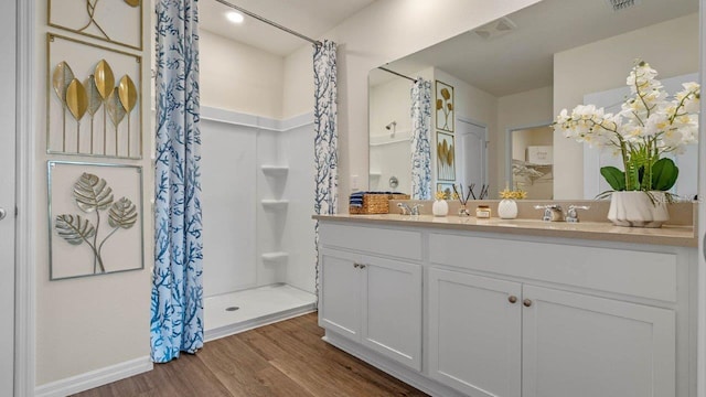 3141 Partington Blvd, Davenport, FL 33837 - bathroom with wood finished floors, double vanity, a shower with curtain, and baseboards