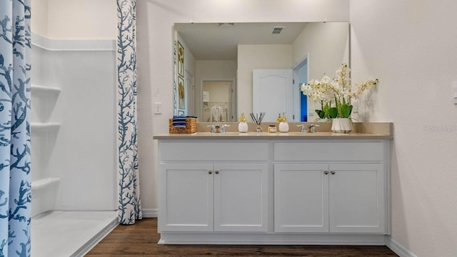 3141 Partington Blvd, Davenport, FL 33837 - full bathroom featuring wood finished floors, double vanity, a shower with shower curtain, and baseboards