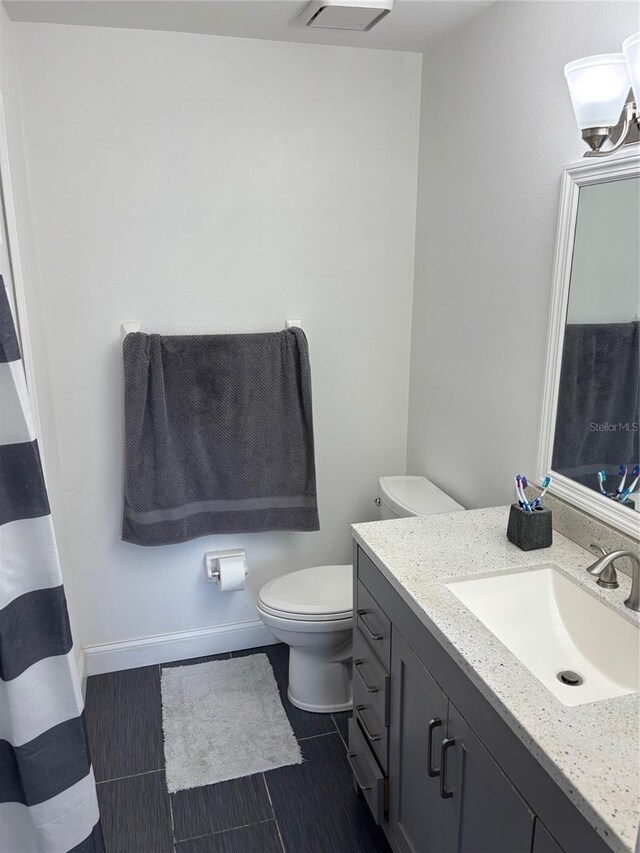 9471 Comeau St, Gotha, FL 34734 - full bath with toilet, vanity, tile patterned floors, and baseboards