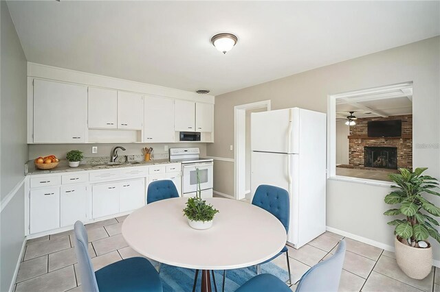2307 Freemason St, Lakeland, FL 33801 - kitchen featuring white appliances, light countertops, light tile patterned floors, white cabinets, and ceiling fan