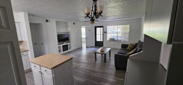 320 Forestway Cir Unit 107, Altamonte Springs, FL 32701 - living room with a textured ceiling, built in shelves, dark wood-type flooring, ceiling fan, and a chandelier