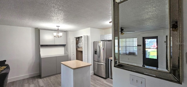 320 Forestway Cir Unit 107, Altamonte Springs, FL 32701 - kitchen with stainless steel refrigerator with ice dispenser, light wood-type flooring, a chandelier, a center island, and a textured ceiling