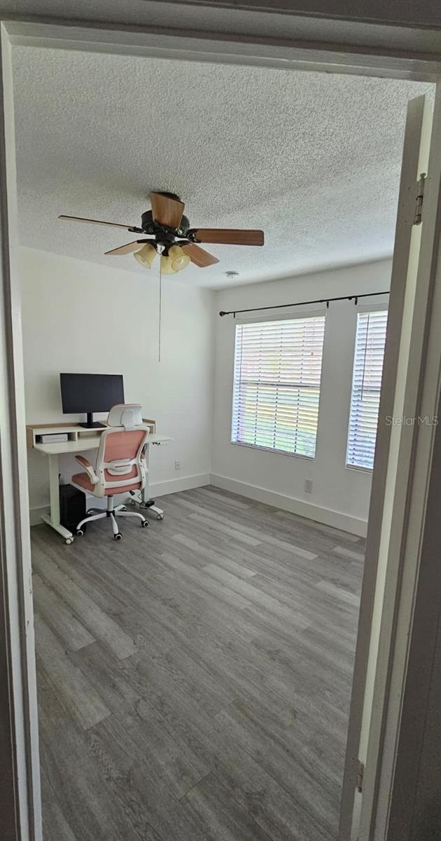 320 Forestway Cir Unit 107, Altamonte Springs, FL 32701 - home office featuring wood finished floors, healthy amount of natural light, a ceiling fan, and a textured ceiling